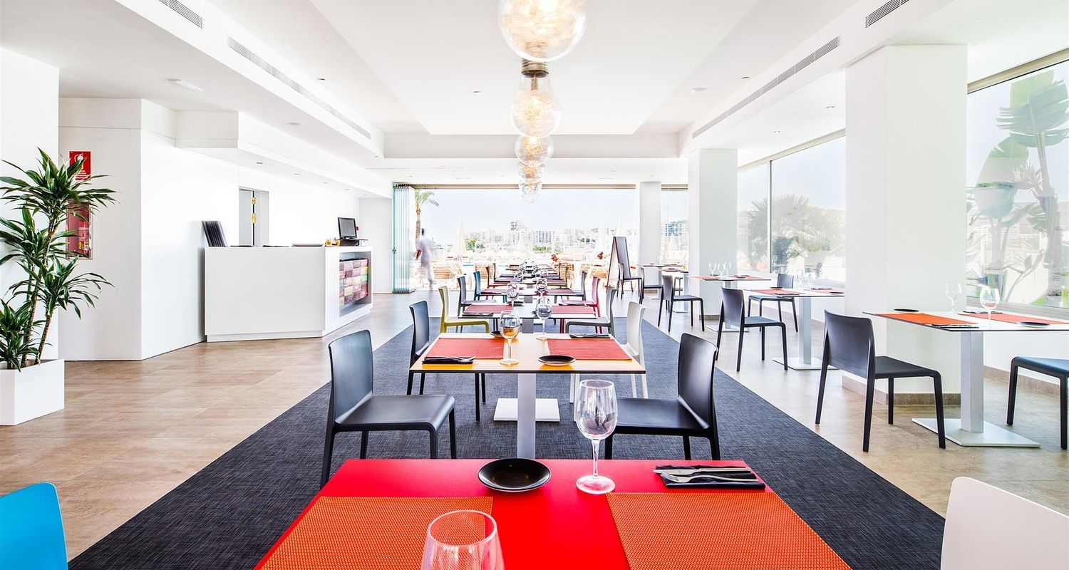spacious dining room with red tables and a black carpet