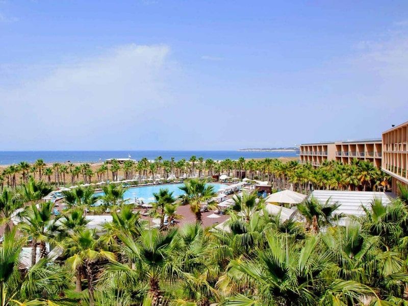 aerial view of the resort showing the outdoor swimming pool, sea views, and the hotel exterior