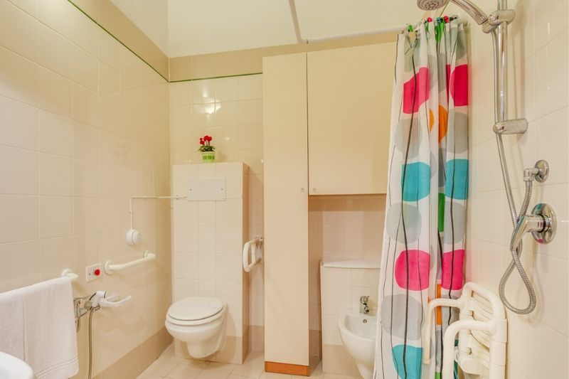 adapted bathroom with grab rails, wheel-in shower and shower chair