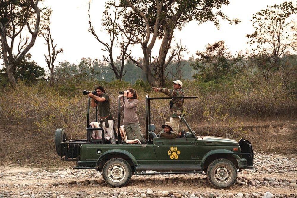 Onlookers park their Jeep to talk a look around with binoculars