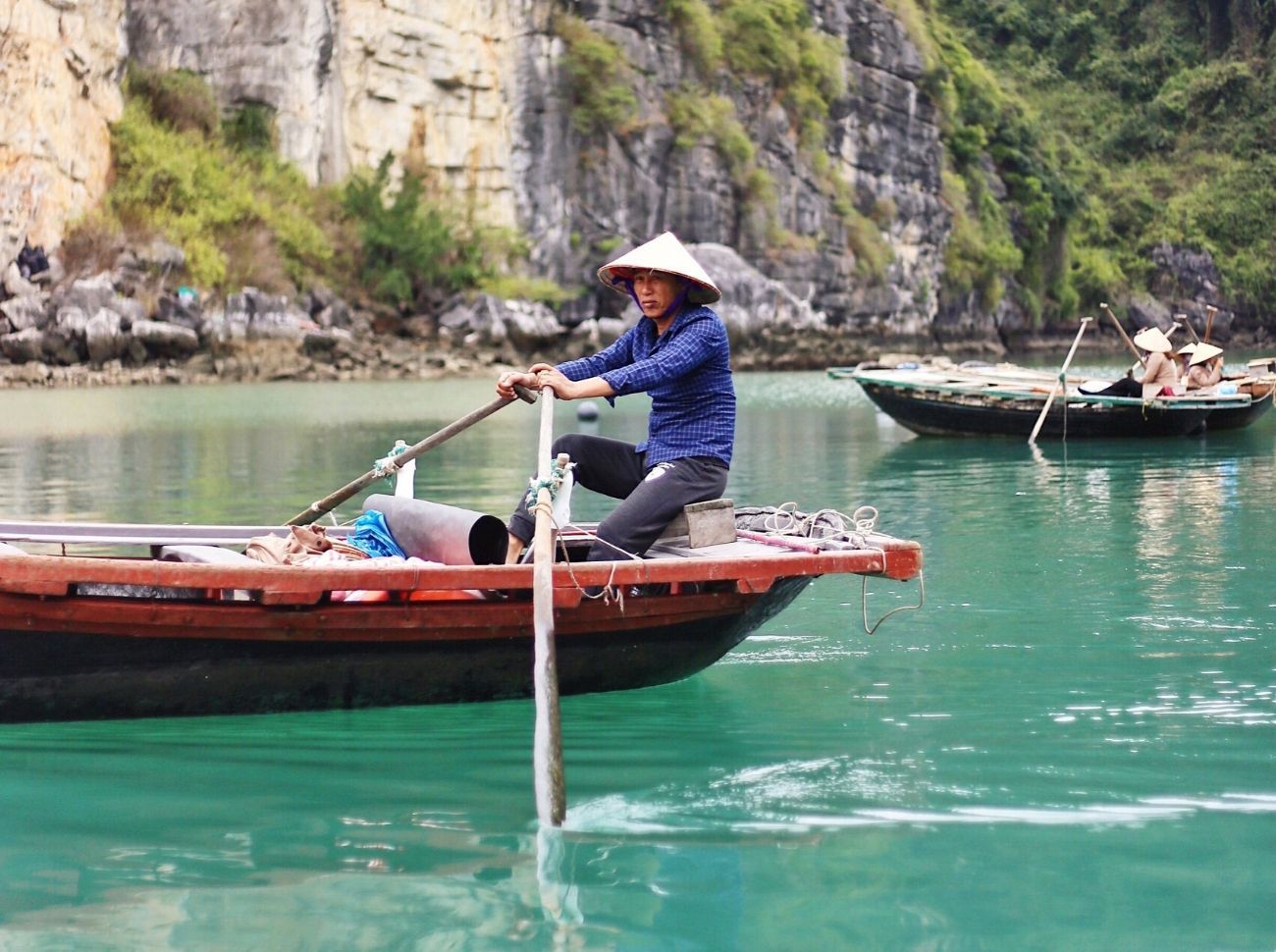 Vietnamese man rowing down the Halong Bay